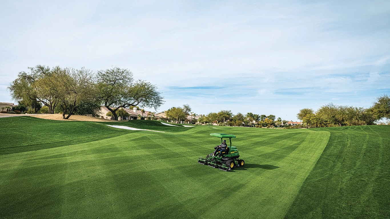 a Deere turf mower tending a golf course
